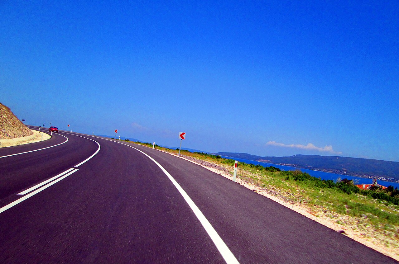 Balıklıova yolu — mavi gökyüzü ve uzakta görünen Ege denizi